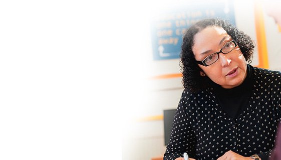 Professional woman in conversation, representing career support and staff development opportunities.